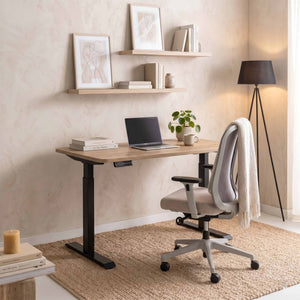 Home office setup with a adjustable desk, chair, and decor elements.