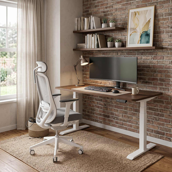 Home office with a desk, chair, and computer setup against a brick wall.
