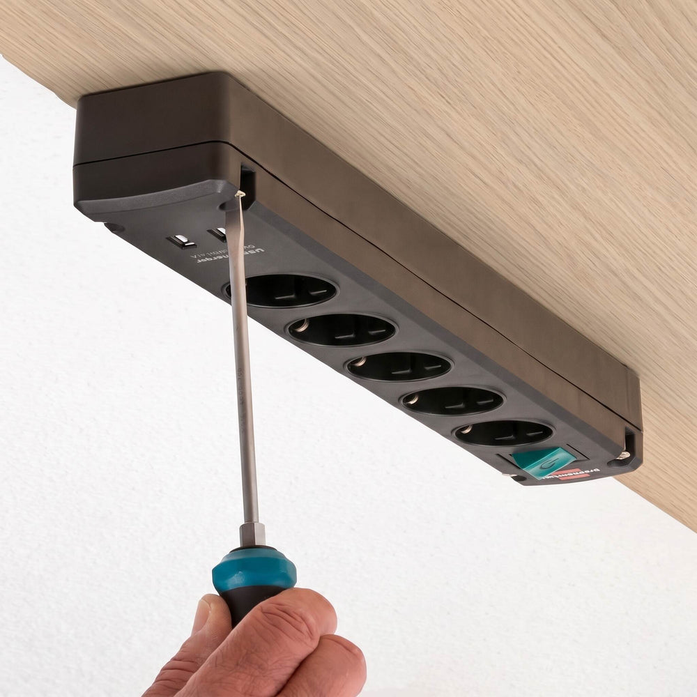 Power strip with multiple outlets being adjusted with a screwdriver on a white background
